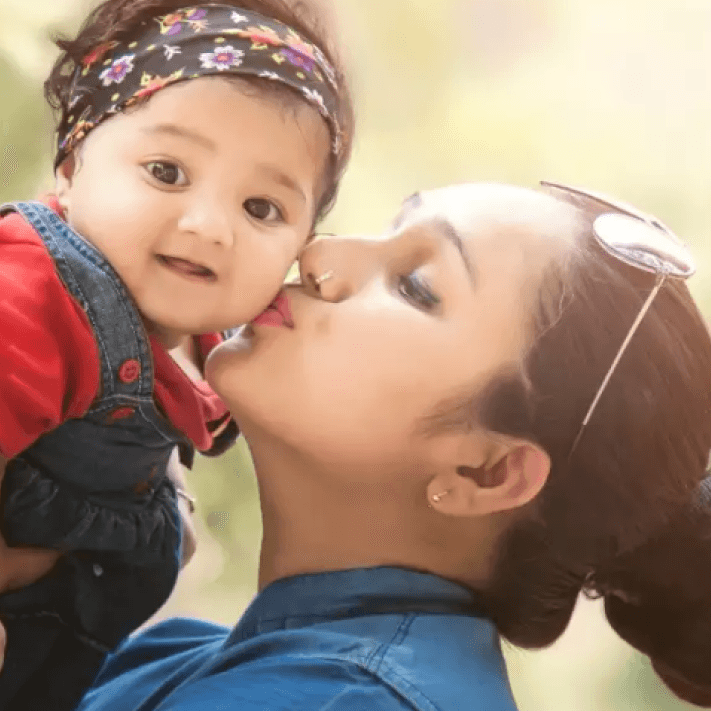 A mother kissing her child