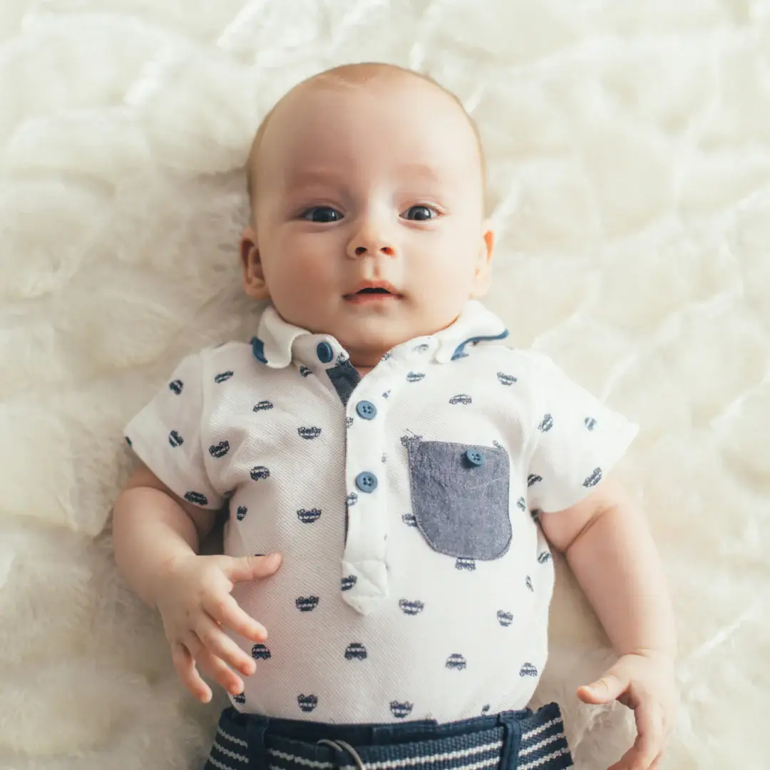 Fair baby laying on a white surface